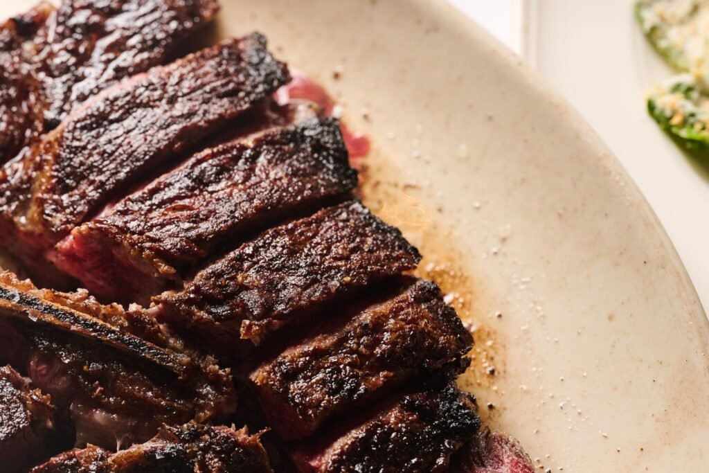 A sliced, charred Delmonico's steak with a pink center