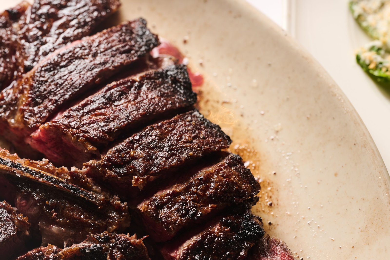 A sliced, charred Delmonico's steak with a pink center