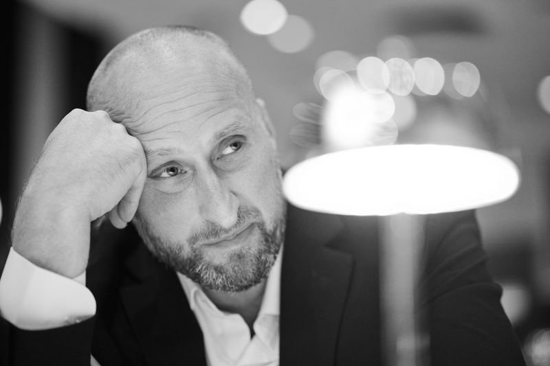 Black-and-white portrait of Dennis Turcinovic, head resting on his hand, deep in thought