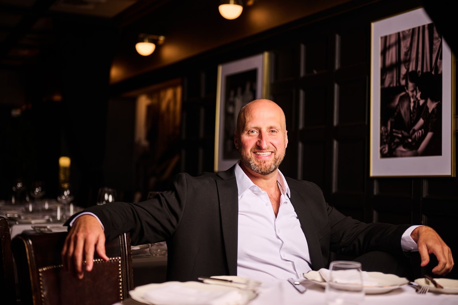Dennis Turcinovic relaxed at a table in a dark-paneled Delmonico's dining room